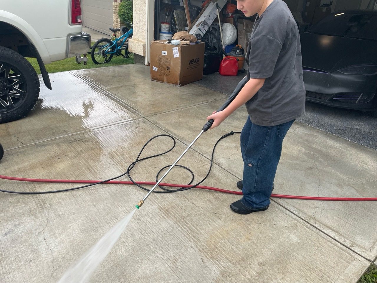 All Washed Up crew member cleaning a concrete driveway