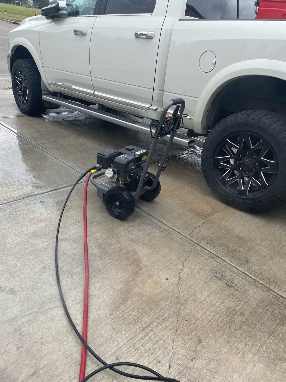 Pressure washer equipment set up beside a driveway